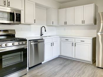 a kitchen with white cabinets and stainless steel appliances  at Sunset Heights, San Antonio, 78209
