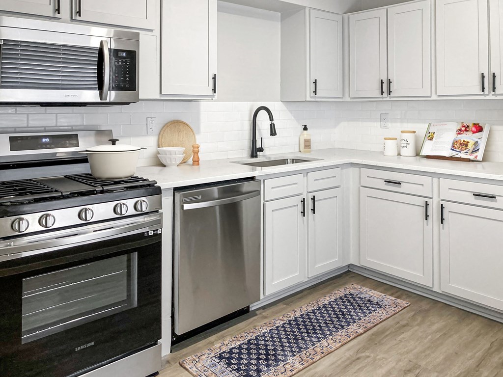 a kitchen with white cabinets and stainless steel appliances  at Sunset Heights, Texas