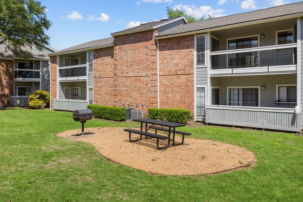 A brick building with a picnic table in front of it.