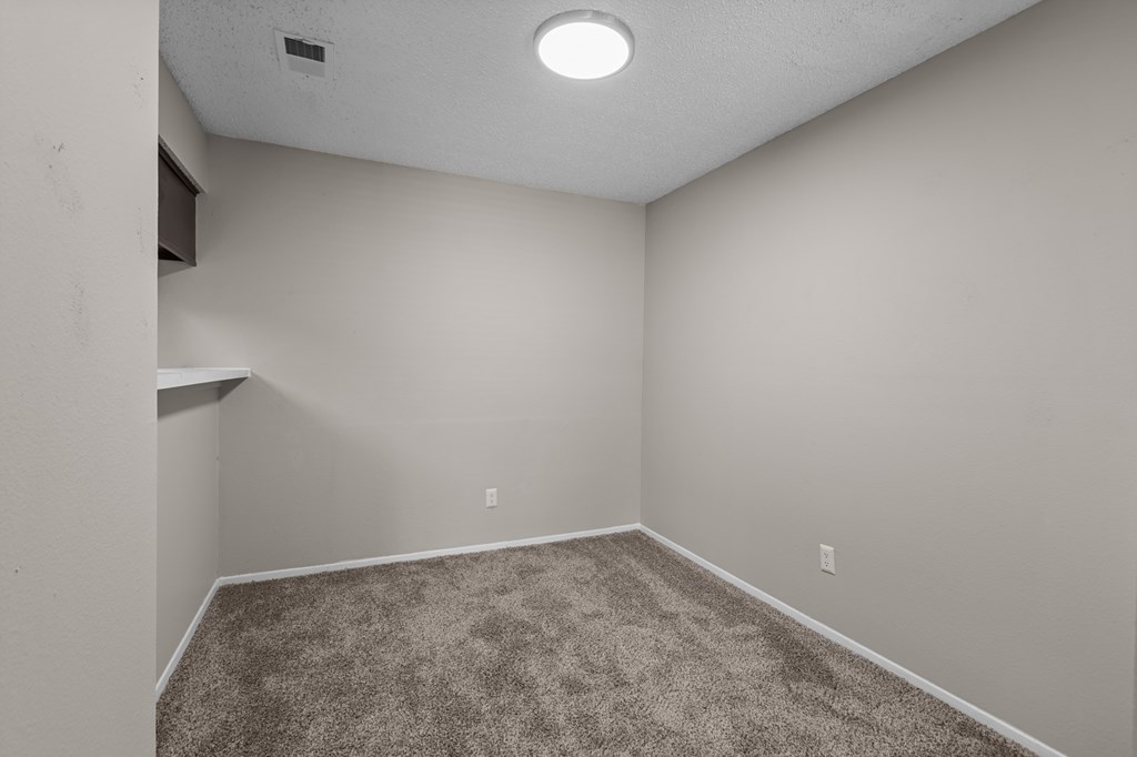 A room with a carpeted floor and a ceiling light.