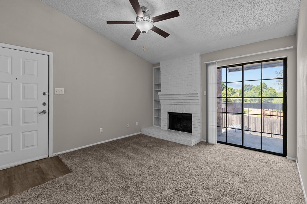 A room with a fireplace and a ceiling fan.