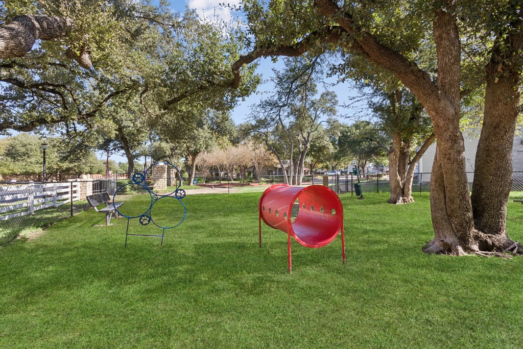 A playground with a red slide and a blue swing set.