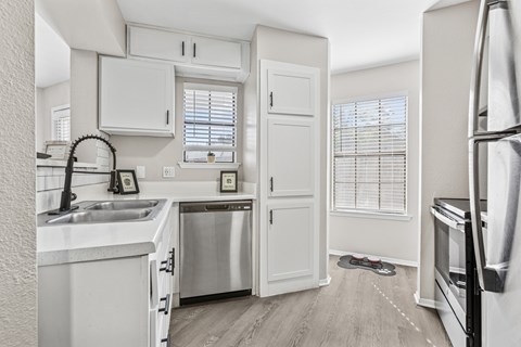 A kitchen with white cabinets and stainless steel appliances.