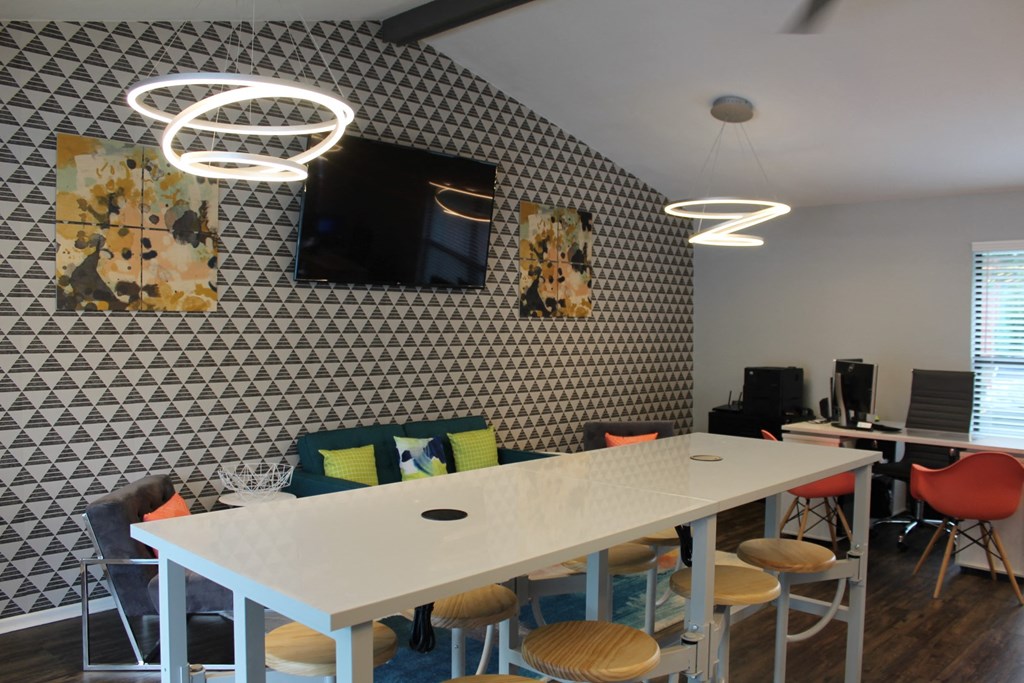 a room with a white table and chairs with colourful cushions on the back of the chairs