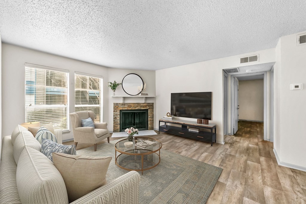 a living room with a wood-burning fireplace and a tv  at Vesper, Dallas, TX