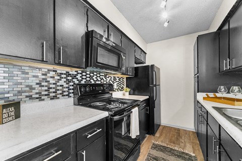 a kitchen with black appliances and white counter tops