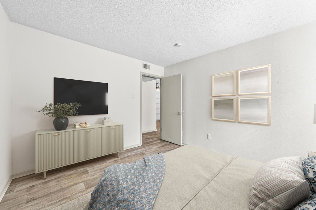 a bedroom with a large bed and a tv on the wall at Vesper, Dallas