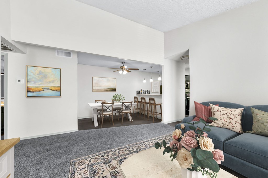 a living room with a couch a table with a chair and a ceiling fan  at Vesper, Dallas, 75254