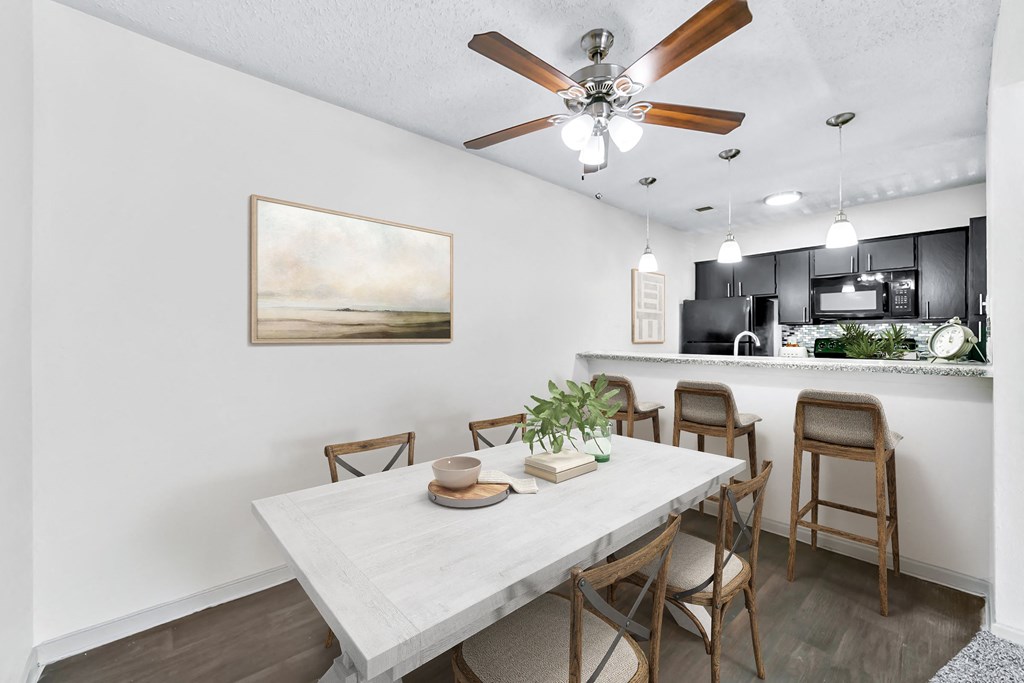 a dining area with a table and chairs, a ceiling fan and a kitchen in the background  at Vesper, Dallas, TX, 75254