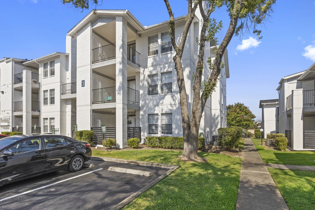a black car parked in front of an apartment building