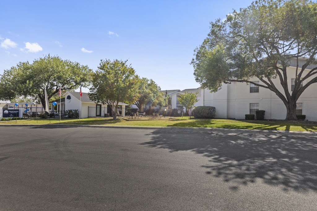 a street with houses and trees and a parking lot