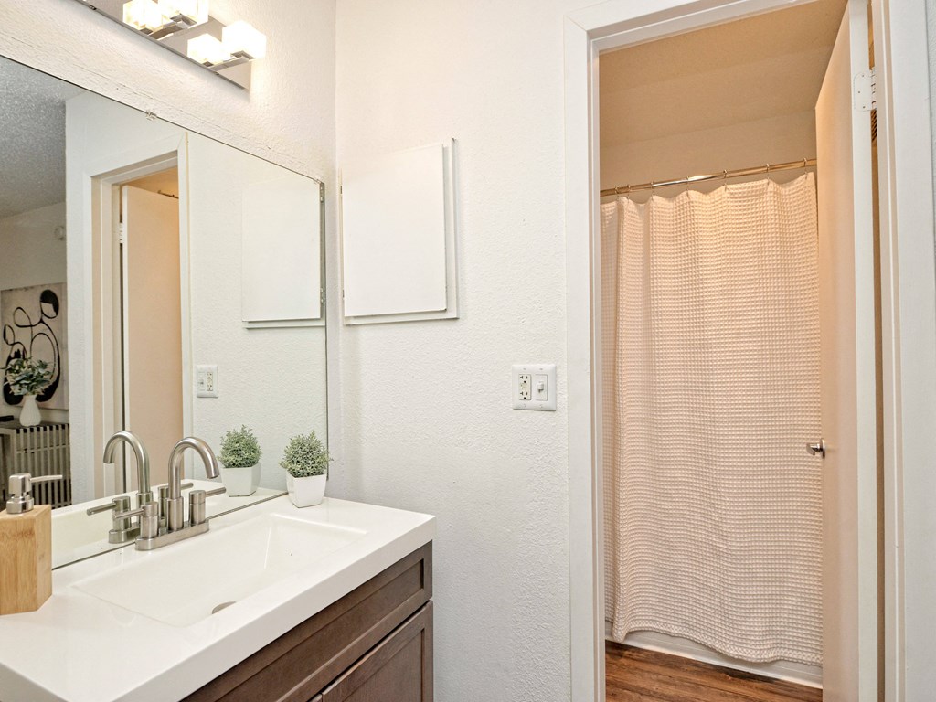 a bathroom with a sink and a shower and a mirror at Peaks at Northwest Hills Apartments, Austin, Texas