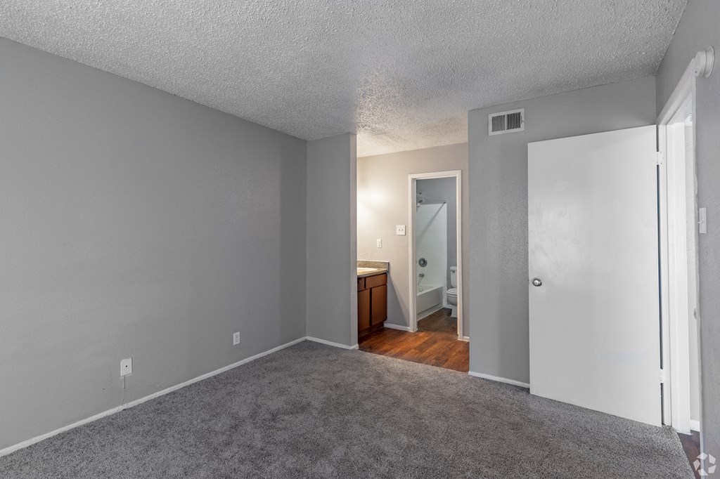 a bedroom with gray walls and a carpeted floor at The Frederick, Texas, 78240