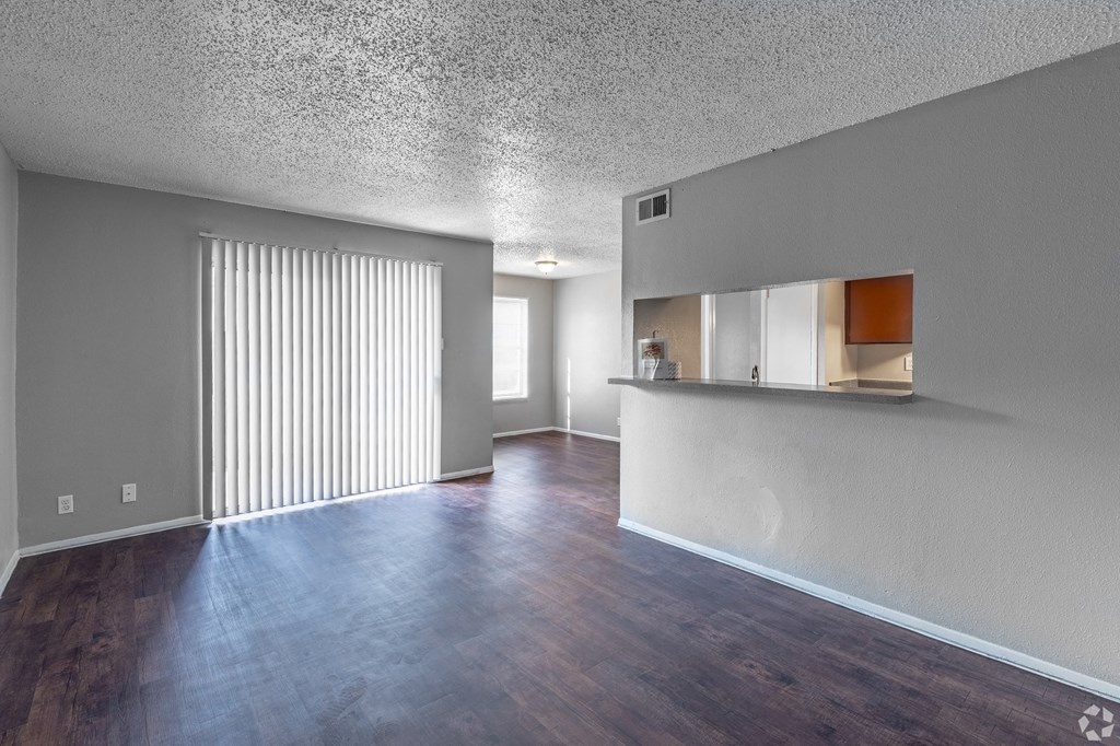 an empty living room with a kitchen in the background at The Frederick, San Antonio, TX