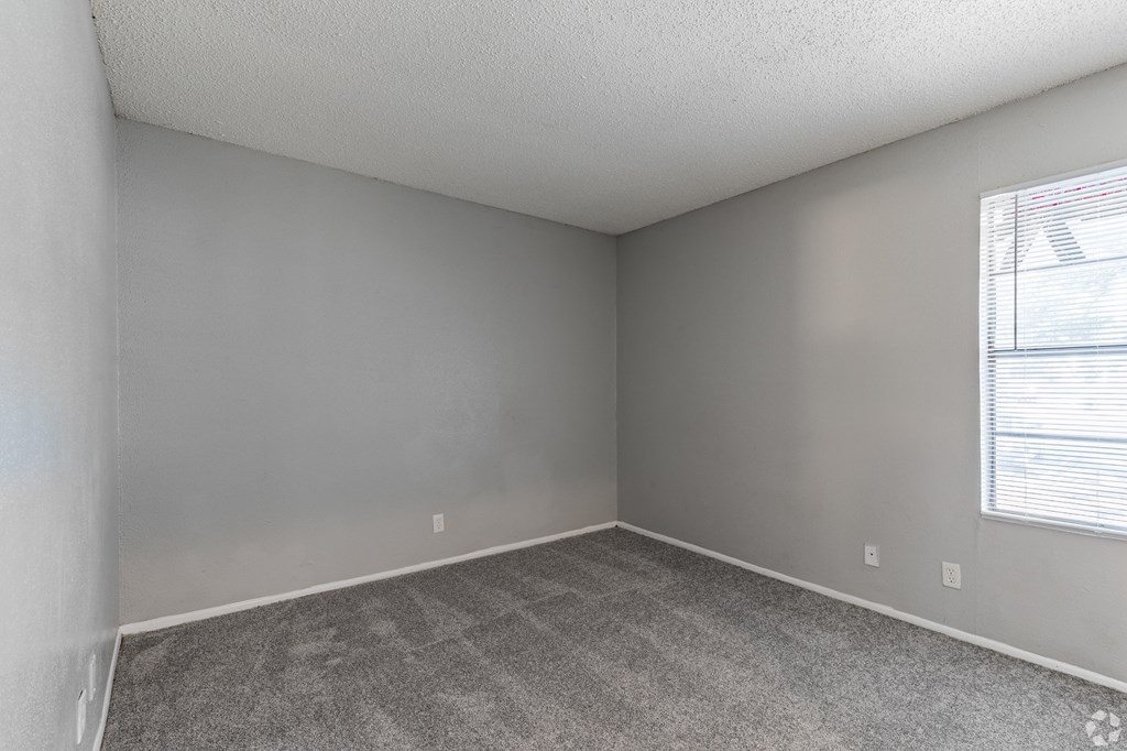 a bedroom with gray walls and a window with a blind at The Frederick, San Antonio, TX 78240