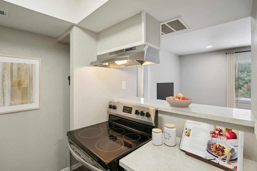 a kitchen with a stove and a microwave and a counter with a bowl of food