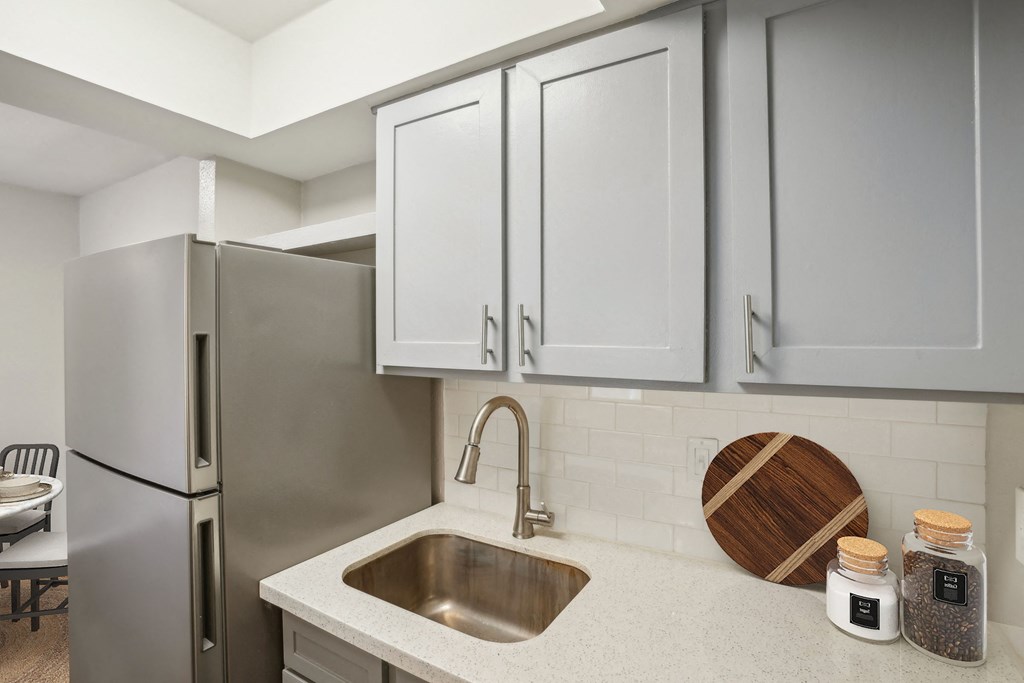 a kitchen with light cabinets and stainless steel appliances and a sink