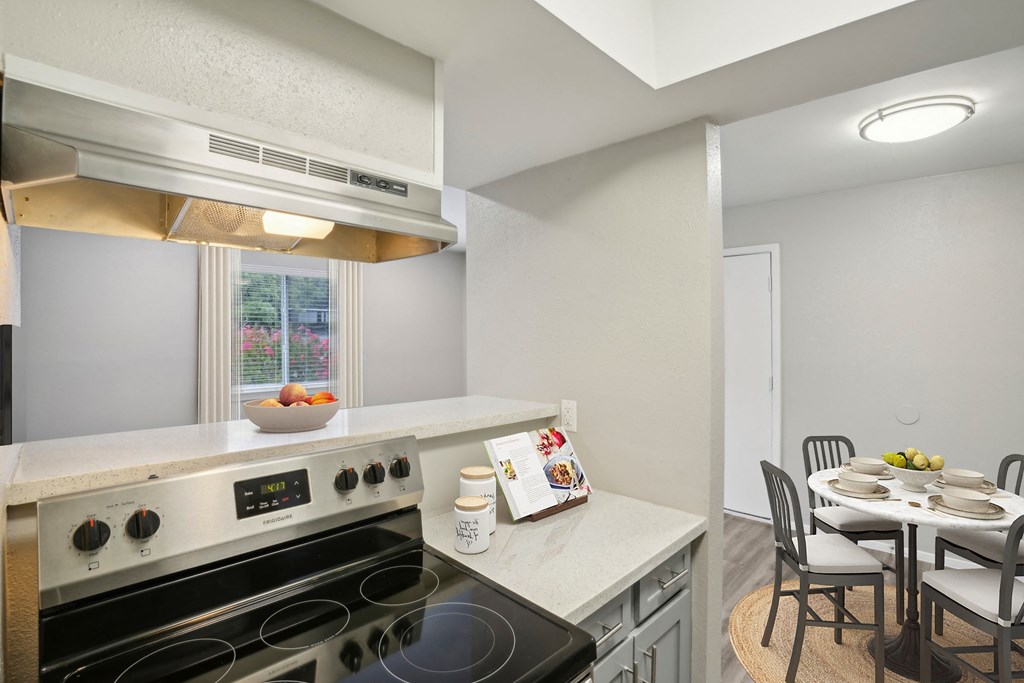 a kitchen with a stove and a table with chairs