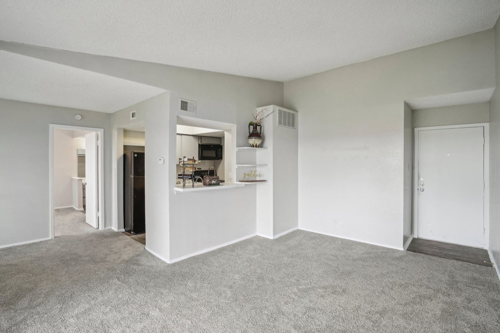 a living room with white walls and carpet