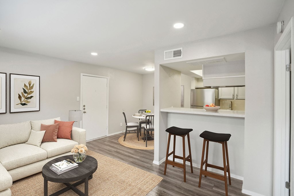 a living room with a couch and a bar and a kitchen