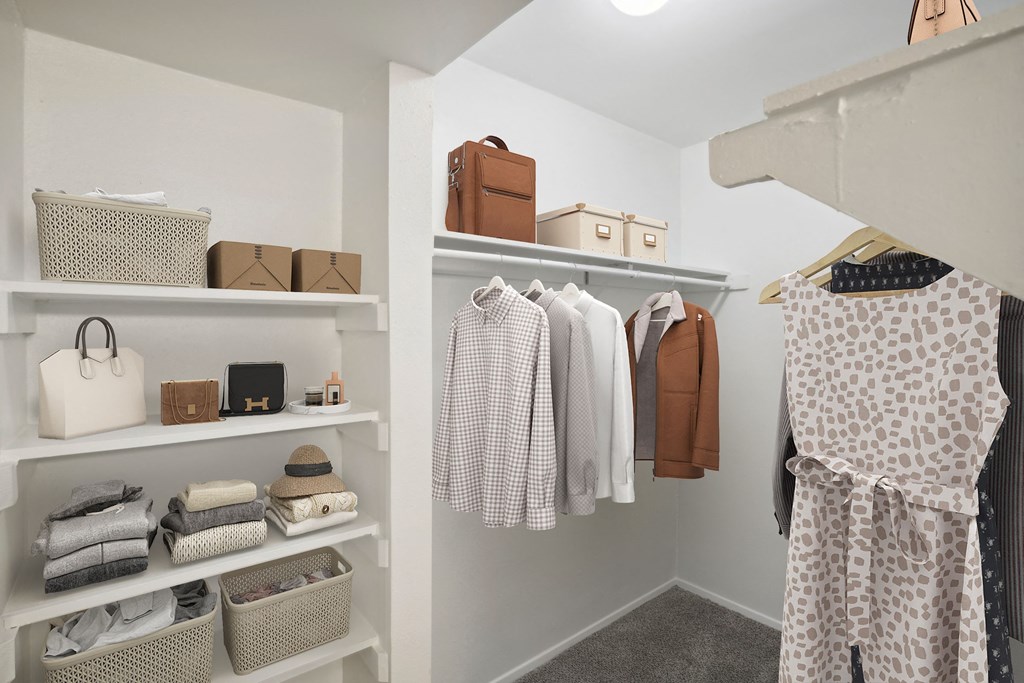 a walk-in closet with shelves filled with clothes and bags