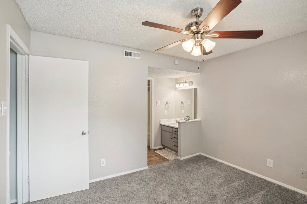 an bedroom with a ceiling fan and a bathroom