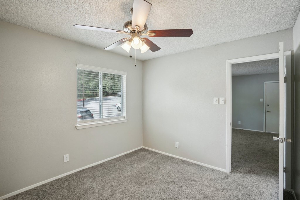 a bedroom with a ceiling fan and a window