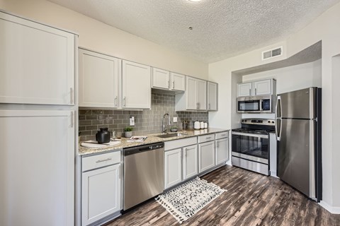 A kitchen with white cabinets and stainless steel appliances.