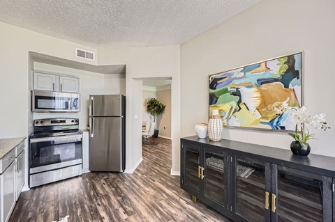 A kitchen with a refrigerator, oven, and cabinets.