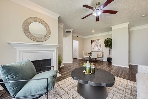A living room with a fireplace, a chair, and a coffee table.