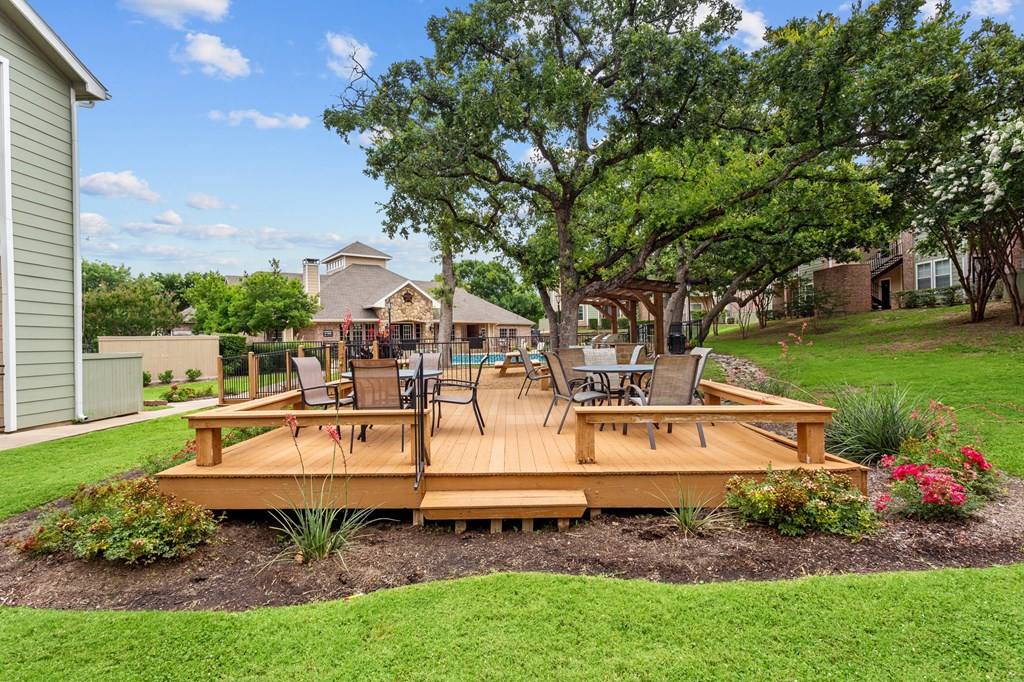 a wooden deck with a table and chairs on it at Southgate Glen, Weatherford, TX