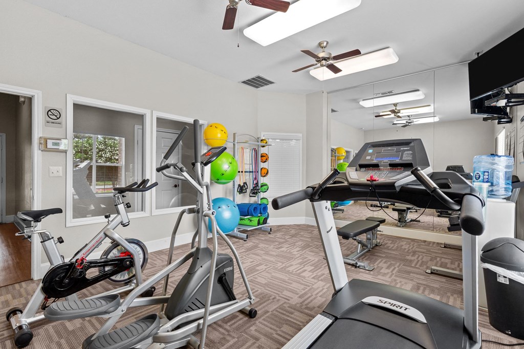 a gym with various exercise equipment in a room with a window at Southgate Glen, Weatherford, 76086
