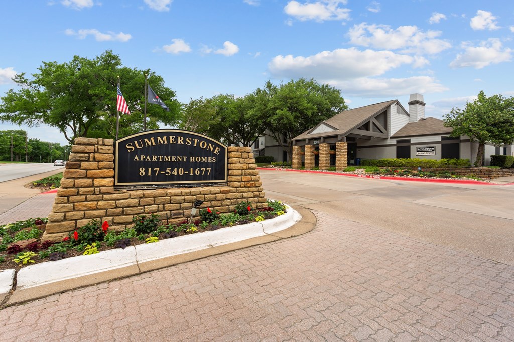 A sign for Summerton Apartment Homes stands in front of a building.