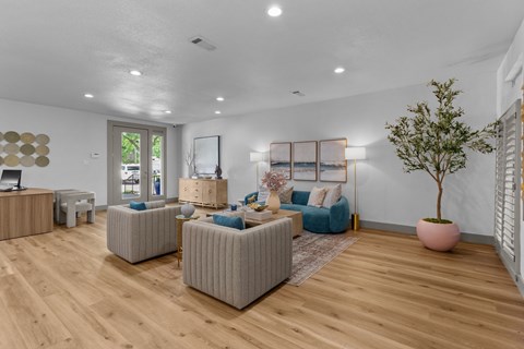 A living room with a blue couch and a pink tree.