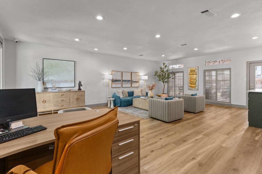 A room with a desk, chair, and a painting on the wall.