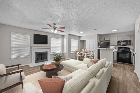 A living room with a white couch and a fireplace.