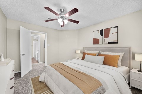 A bedroom with a large bed and a ceiling fan.
