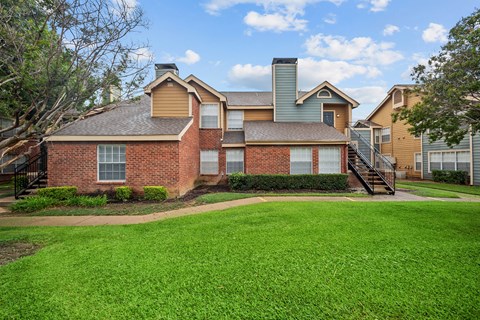 A large house with a green lawn in front.