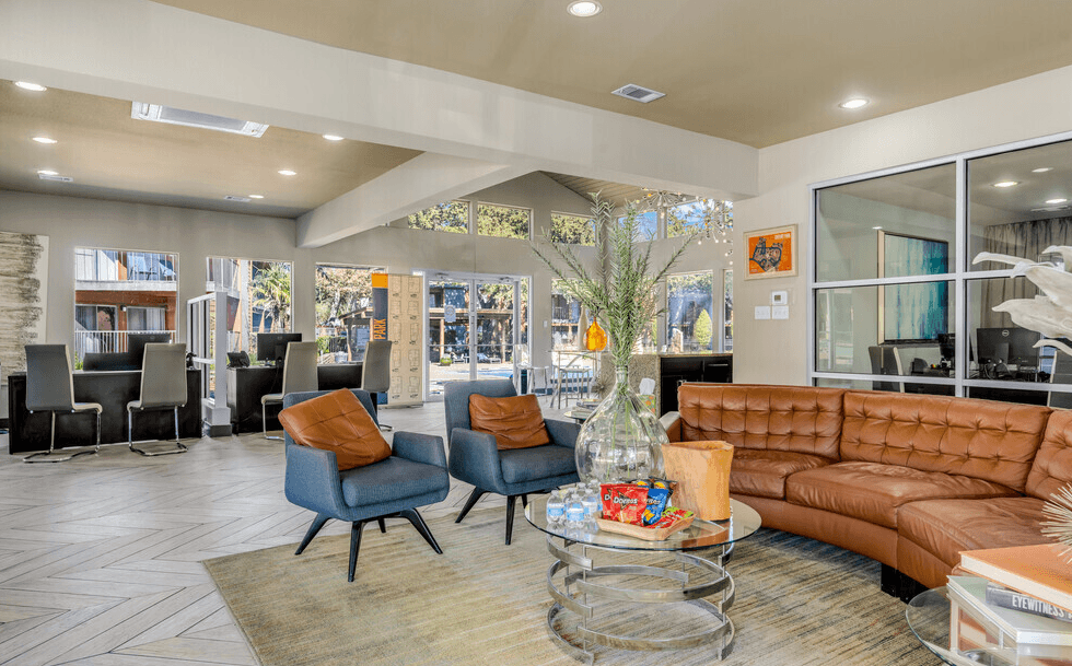 A living room with a brown couch and blue chairs.