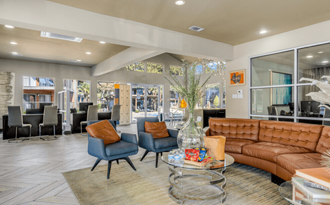 A living room with a brown couch and blue chairs.