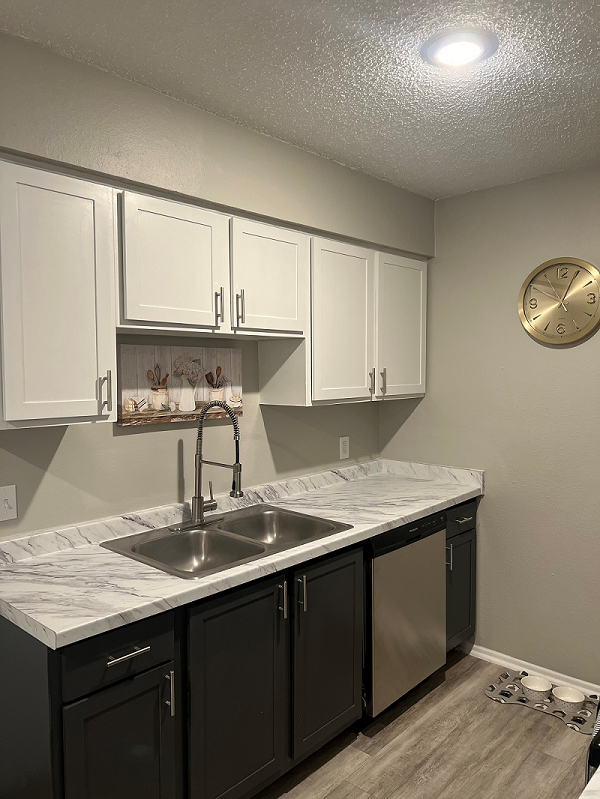 a kitchen with white cabinets and a clock on the wall