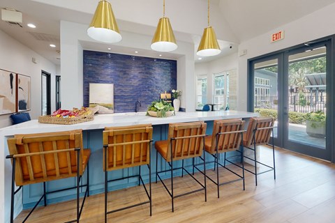 a kitchen with a large island and chairs in front of a window