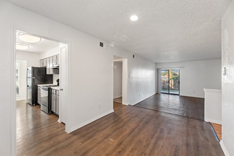 A spacious room with wooden floors and white walls.