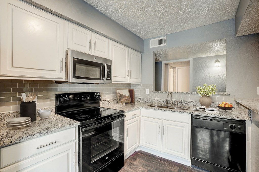 a kitchen with black appliances and white cabinets