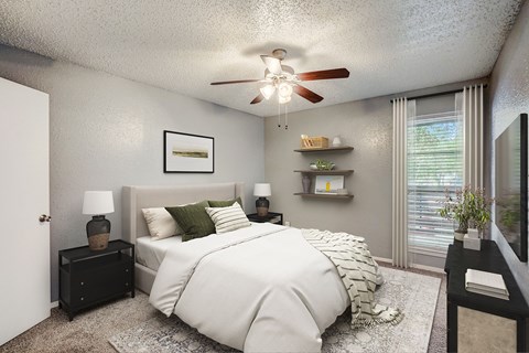 our apartments offer a bedroom with a large bed and a ceiling fan
