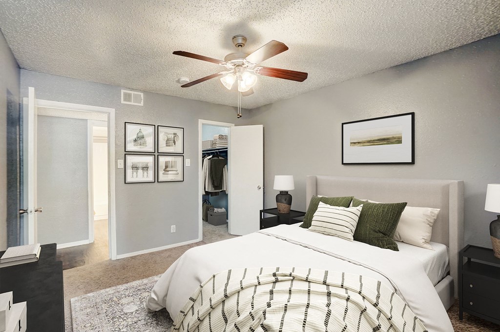 an open bedroom with a large bed and a ceiling fan