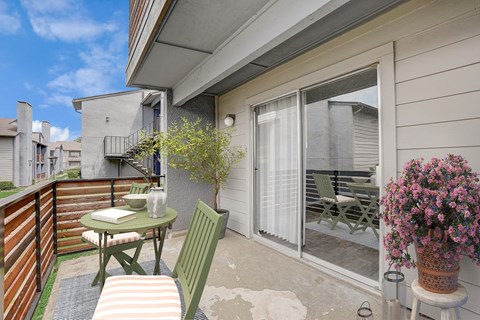 a patio with a table and chairs and a sliding glass door