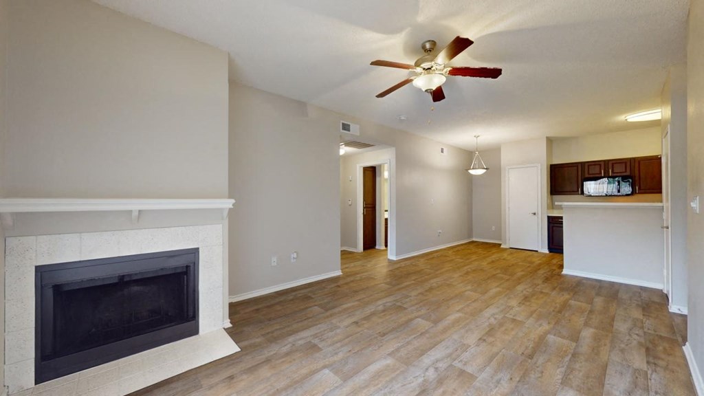 a living room with a fireplace and a ceiling fan at Southgate Glen, Weatherford, Texas