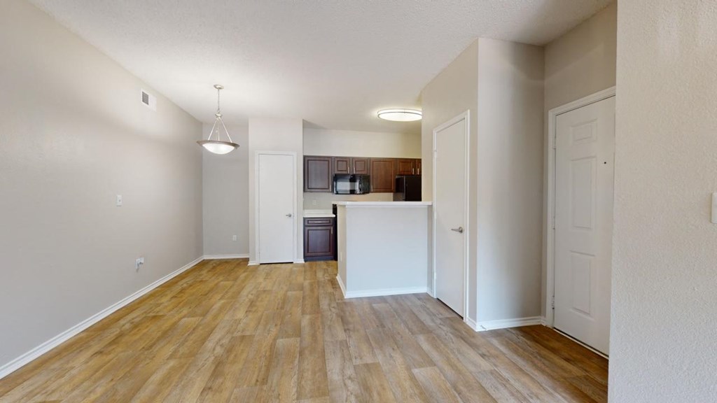 an empty living room and kitchen with wood flooring at Southgate Glen, Weatherford, TX