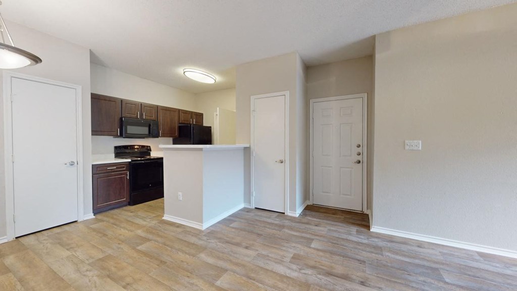 an empty kitchen and living room with a door to the bathroom at Southgate Glen, Weatherford